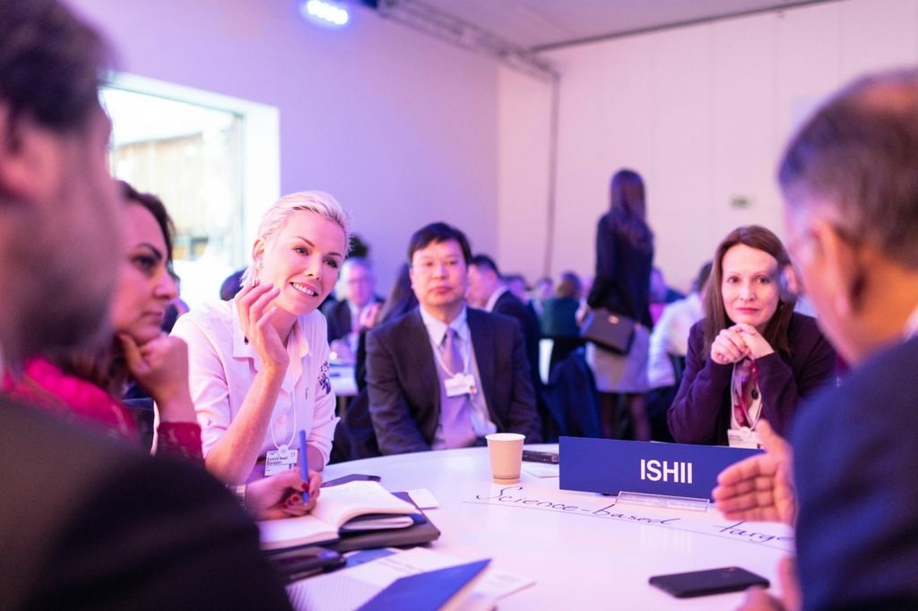 Group of office executives sitting on a round table in a conference setting.