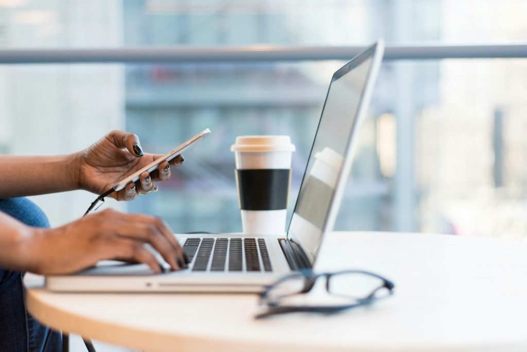 A person using laptop on a round tea table.